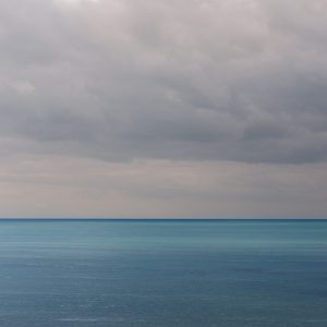 Sunlit blue sea and grey sky from Gun Cliff, Lyme Regis 01_07_23