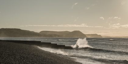 Sunlit wave breaking on the sea wall at Cobb Gate, Lyme Regis 27_09_21 pano