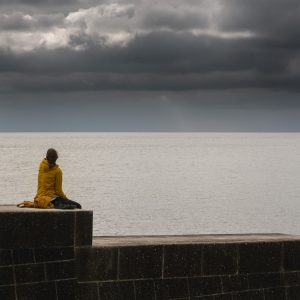 Woman sitting on Cobb Gate Beach sea wall, Lyme Regis 14_05_21 pano