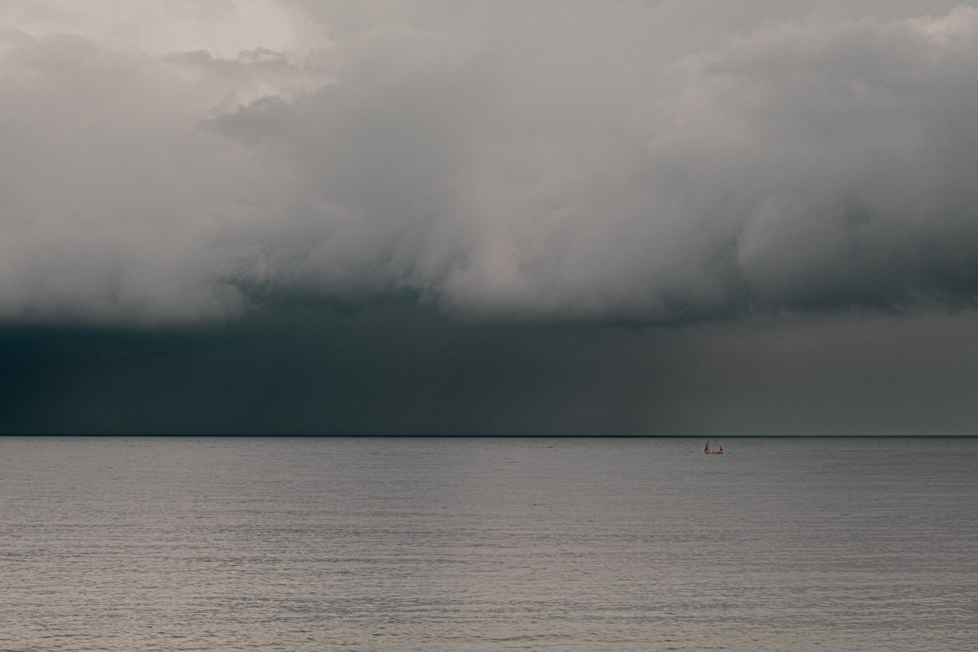 Dark sky with low cloud over the sea with fishing boat off Front Beach Lyme Regis 22_05_24