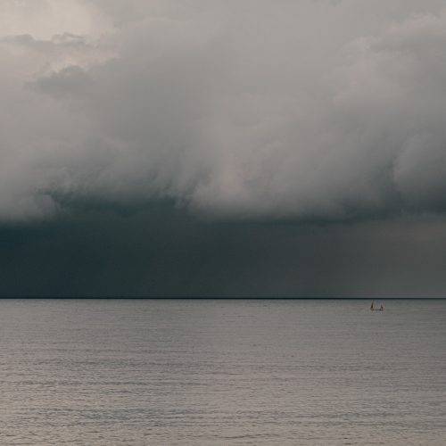 Dark sky with low cloud over the sea with fishing boat off Front Beach Lyme Regis 22_05_24
