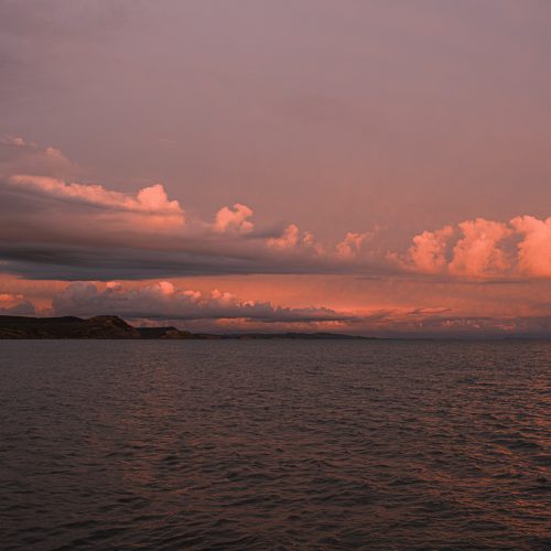 Orange tinted sunset cloudscape over the sea and coast from Gun Cliff Walk Lyme Regis 26_03_24