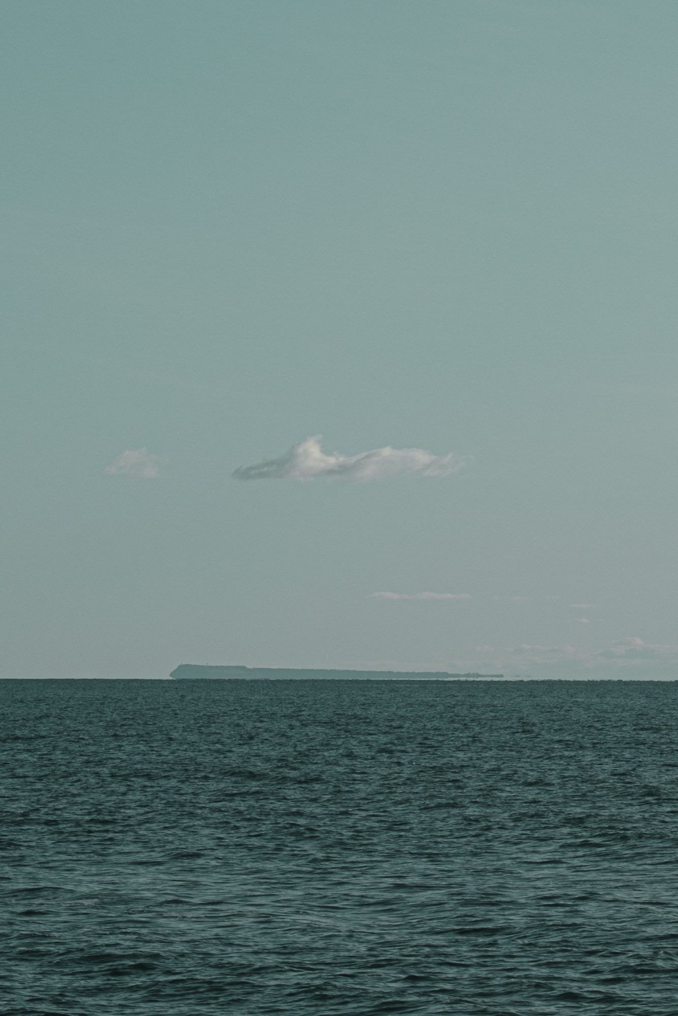 Small cloud in a blue sky over Portland and the sea from Long Entry Lyme Regis 16_01_24